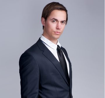 demo-attachment-1114-handsome-young-businessman-standing-against-gray-PFGZN4E